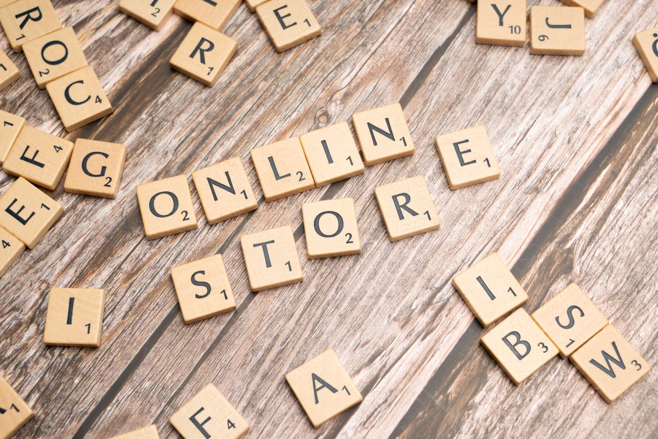 Scrabble tiles spelling online store on a rustic wooden background.